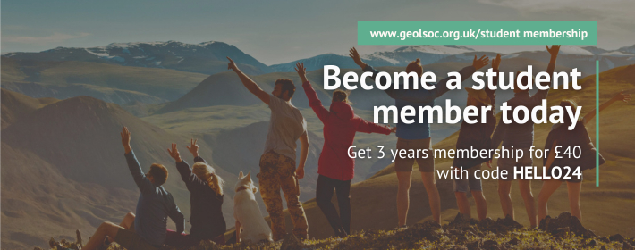 A group of friends standing on a mountain with their hands in the air